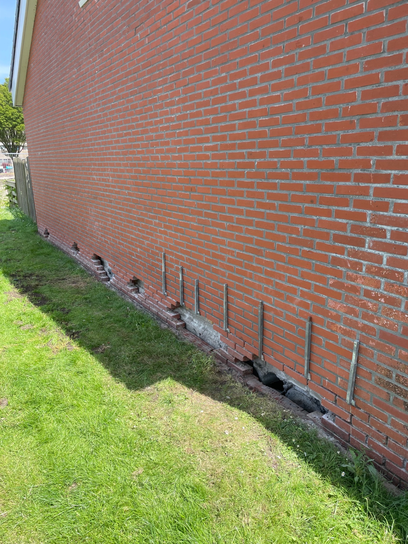 Inspectieput langs een gemetselde fundering met spouwankers